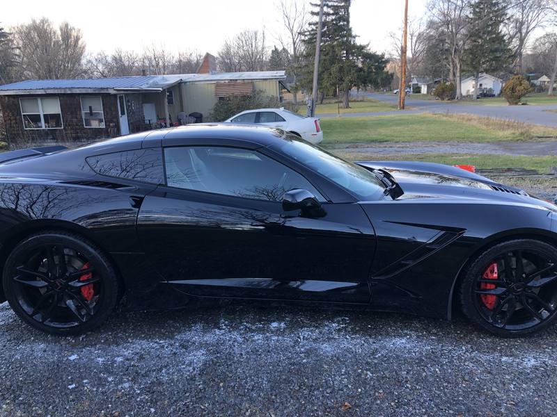 Mobile car detailing in Charlotte, NC: Side profile of a black C7 Corvette Stingray with mirror-like paint reflections after a detail